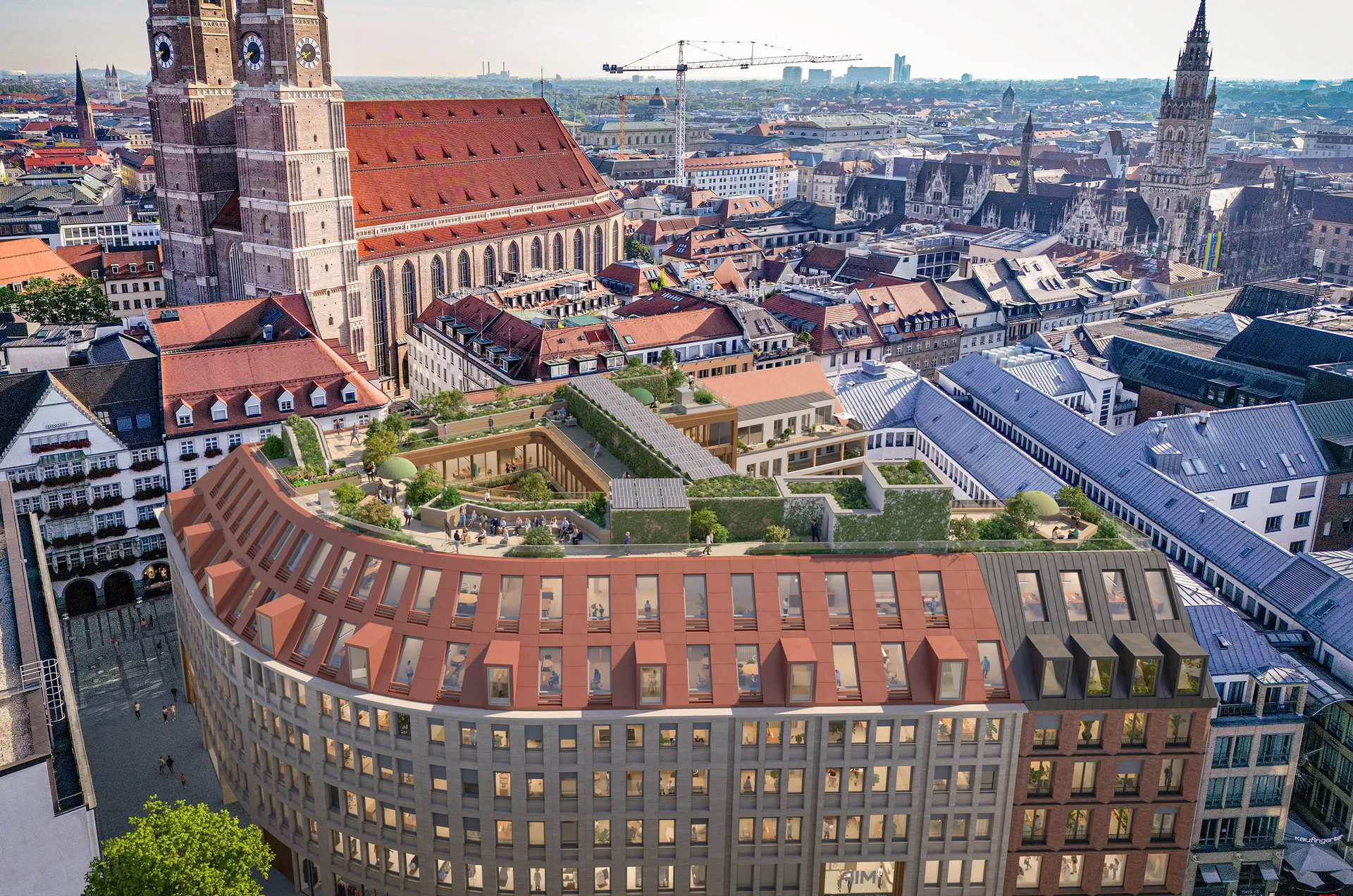 Luftaufnahme von München zeigt das moderne AIM-Gebäude vor der historischen Frauenkirche im Stadtzentrum.